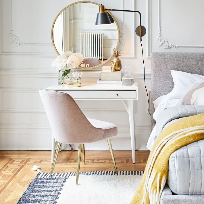 One 2021 design trend is double duty decor like this small desk that doubles as a nightstand