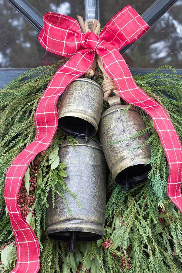 Backyard greenery and a trio of bells for a simple front door holiday swag instead of a wreath