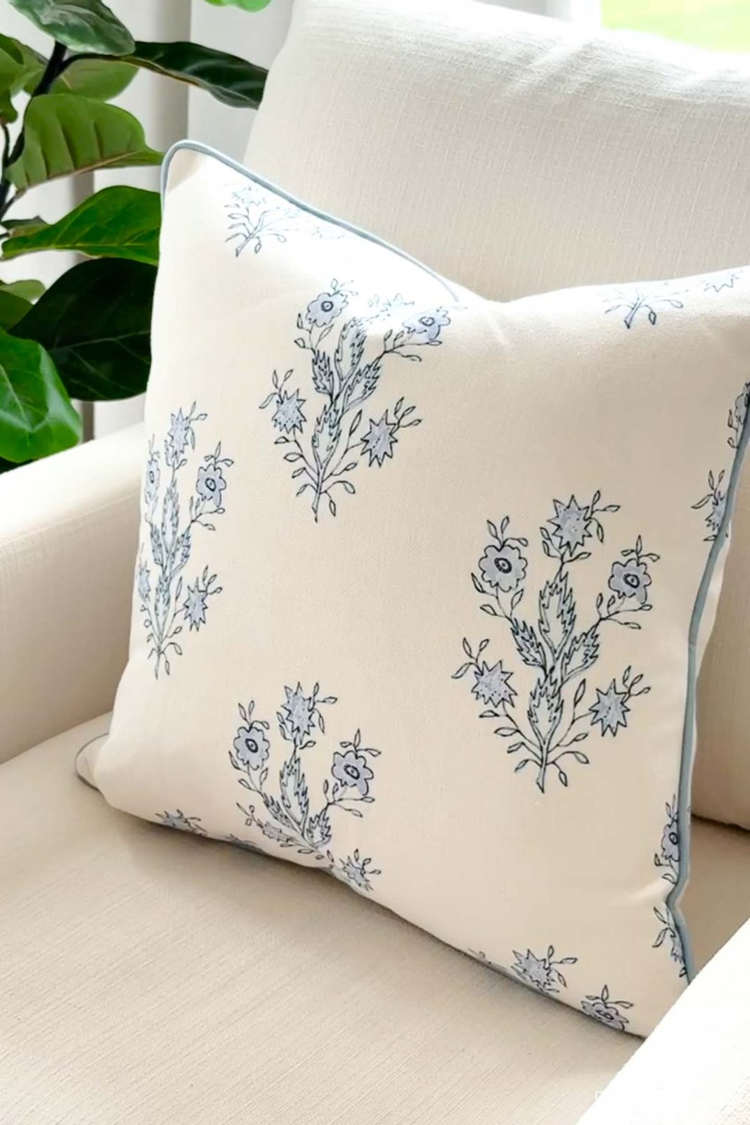 Blue and white floral pillow cover on upholstered chair