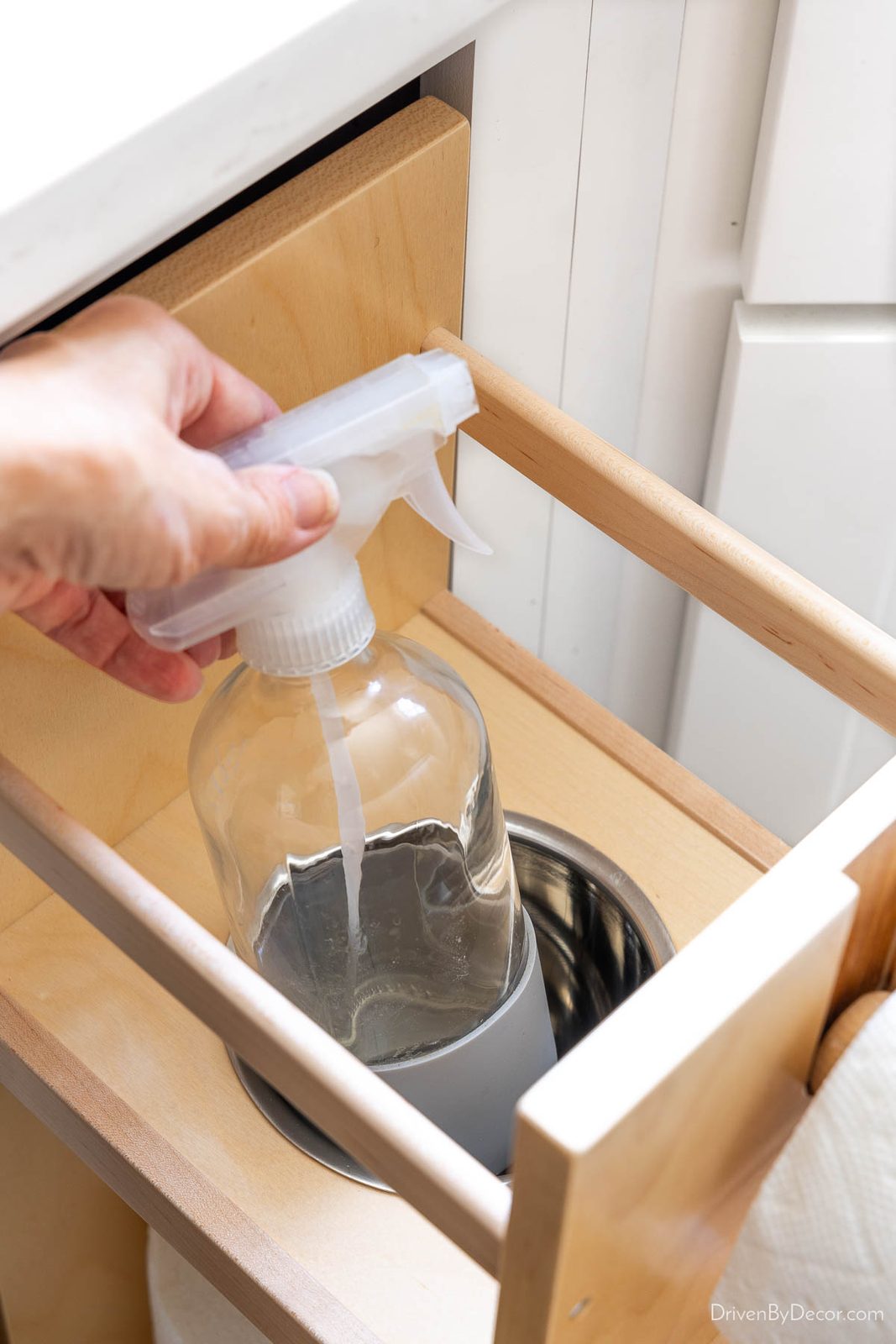 Spray bottle stored in built-in paper towel pullout