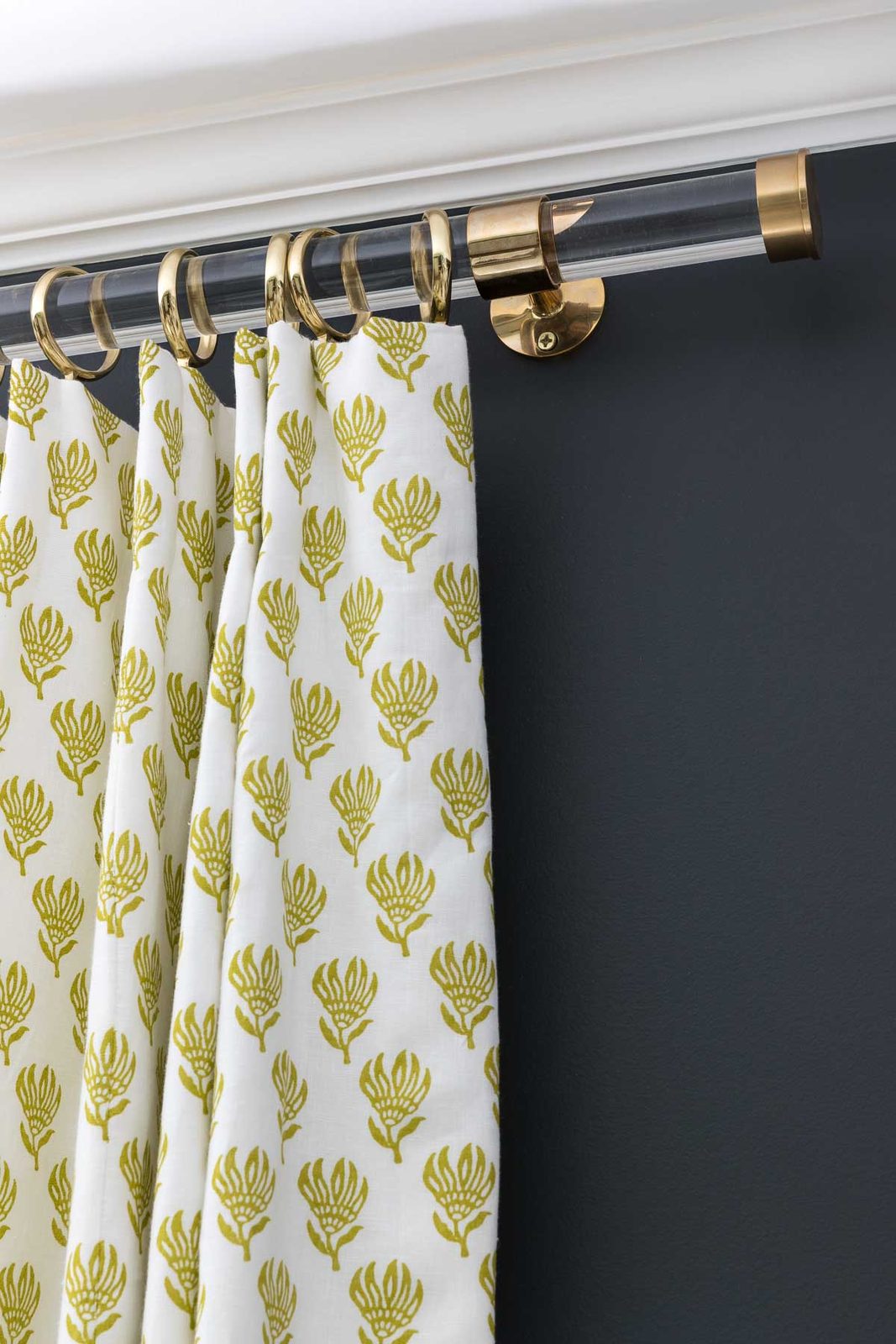 Brass curtain hardware against charcoal gray walls