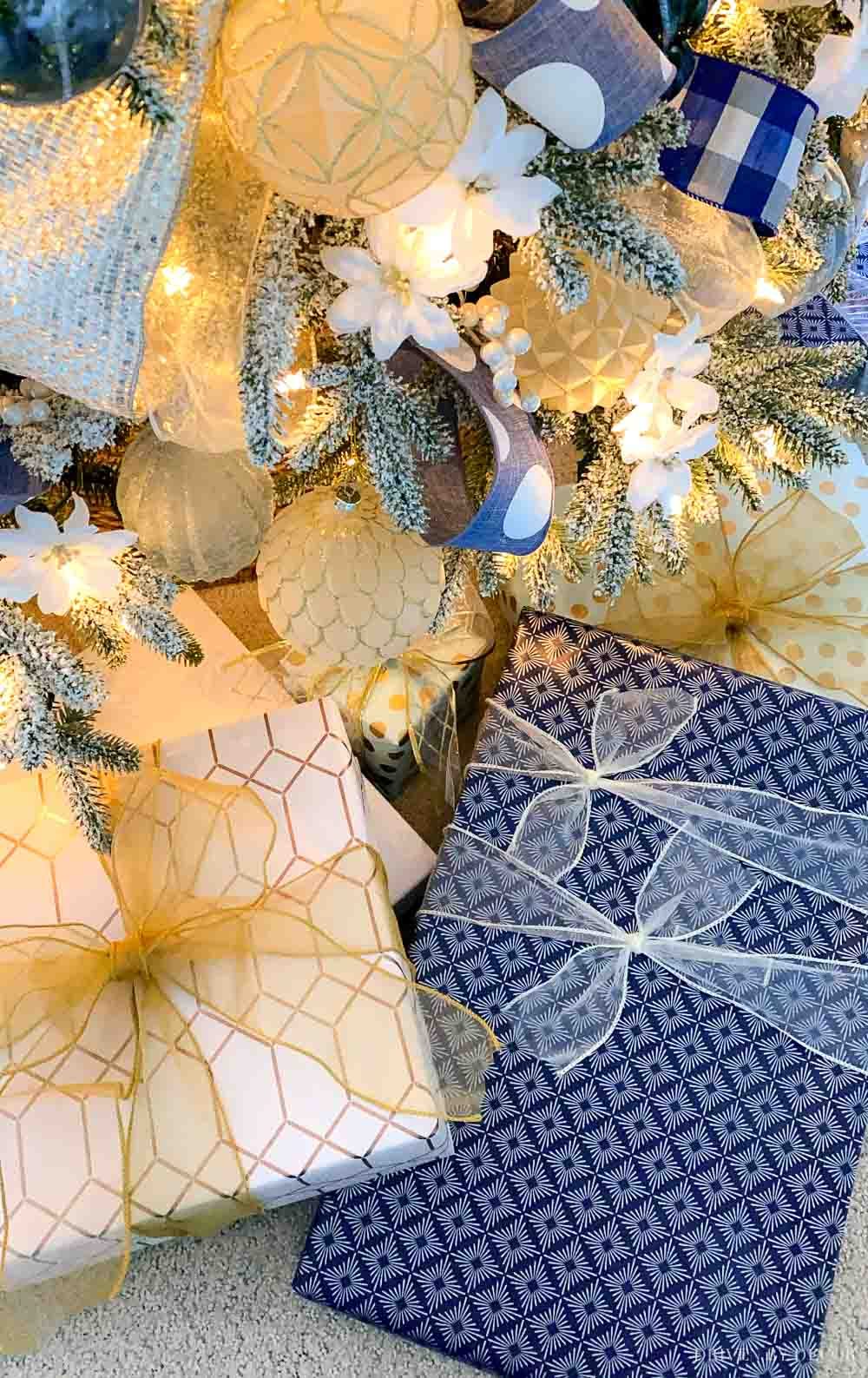 Packages wrapped in blue and white under the Christmas tree