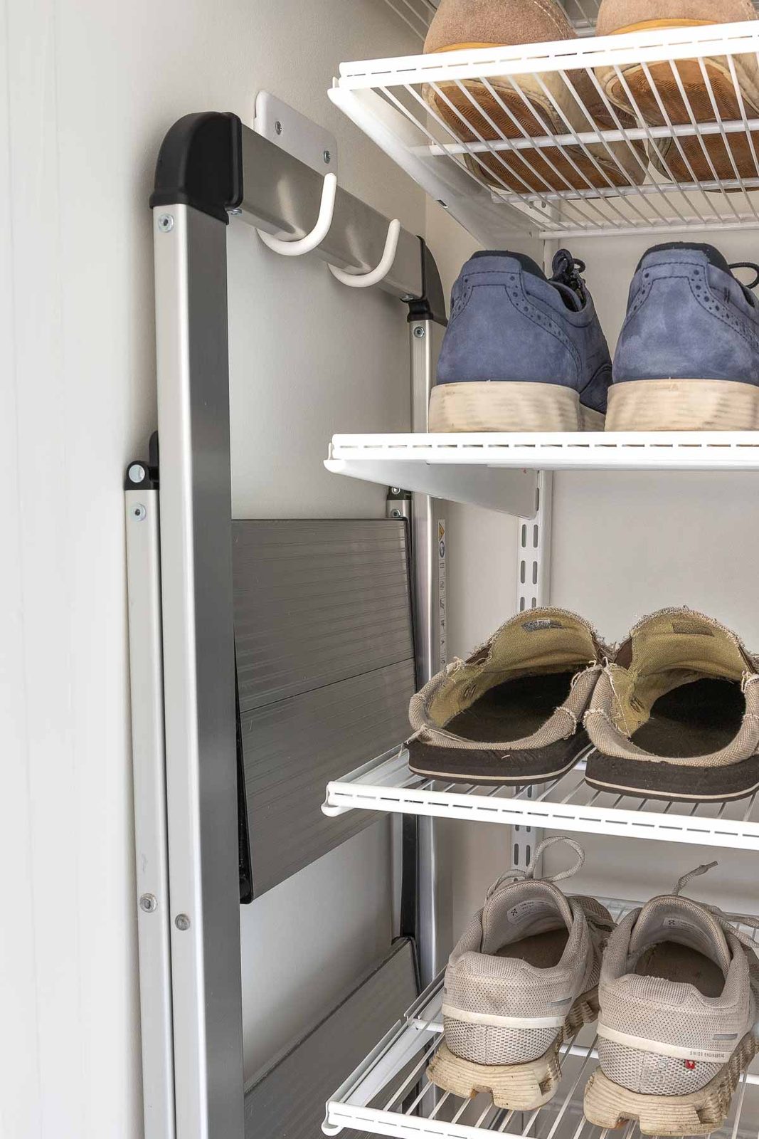 Step stool hanging on wall hooks in laundry room closet