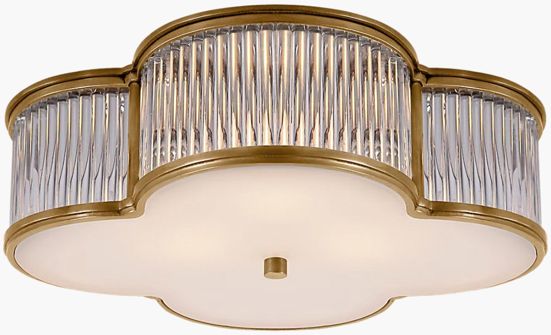 Clover-shaped flush mount light fixture lined in brass with glass rods