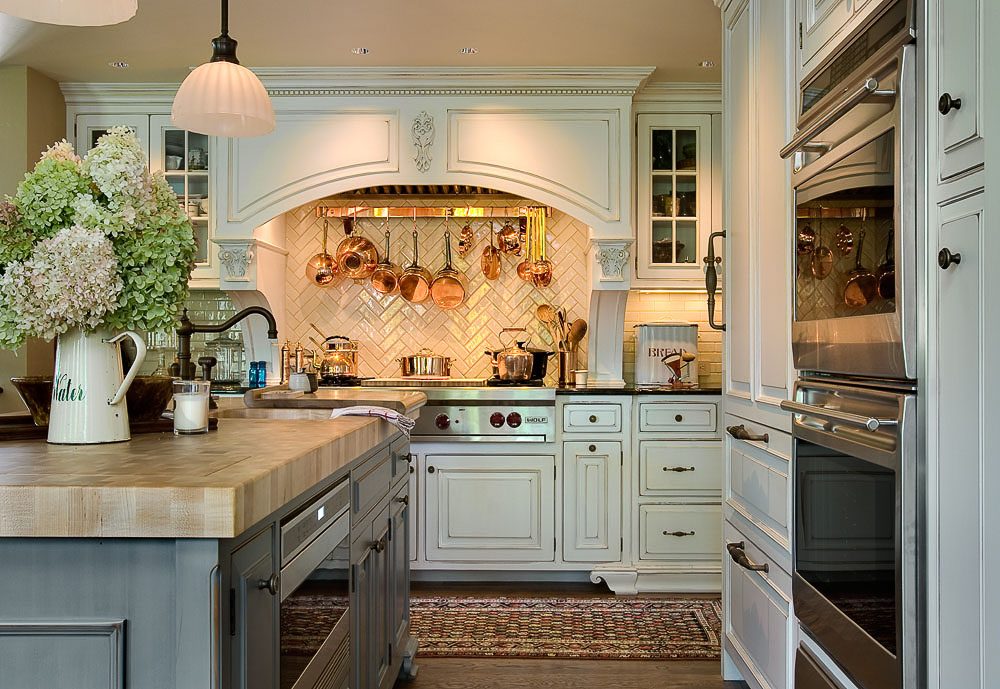 Gorgeous copper kitchen accents with pots hanging over the range