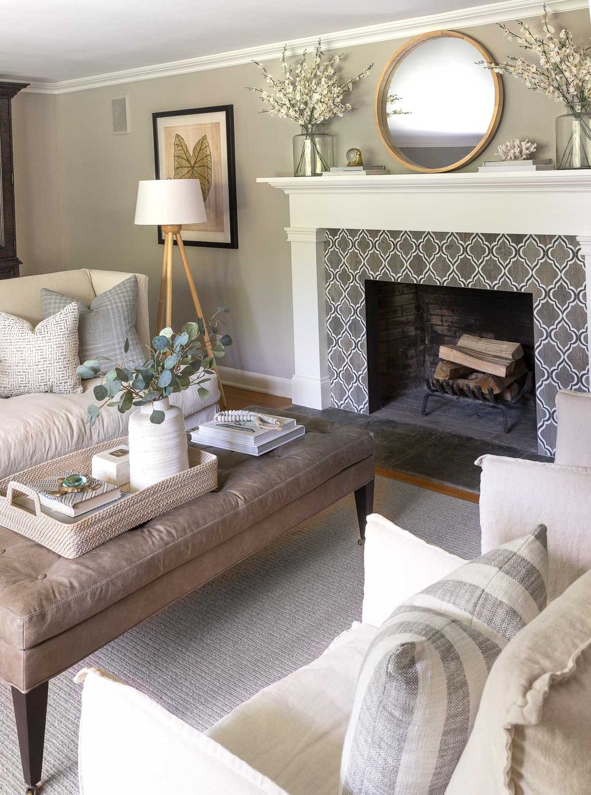 Faux orchids in glass vases on fireplace mantel in living room