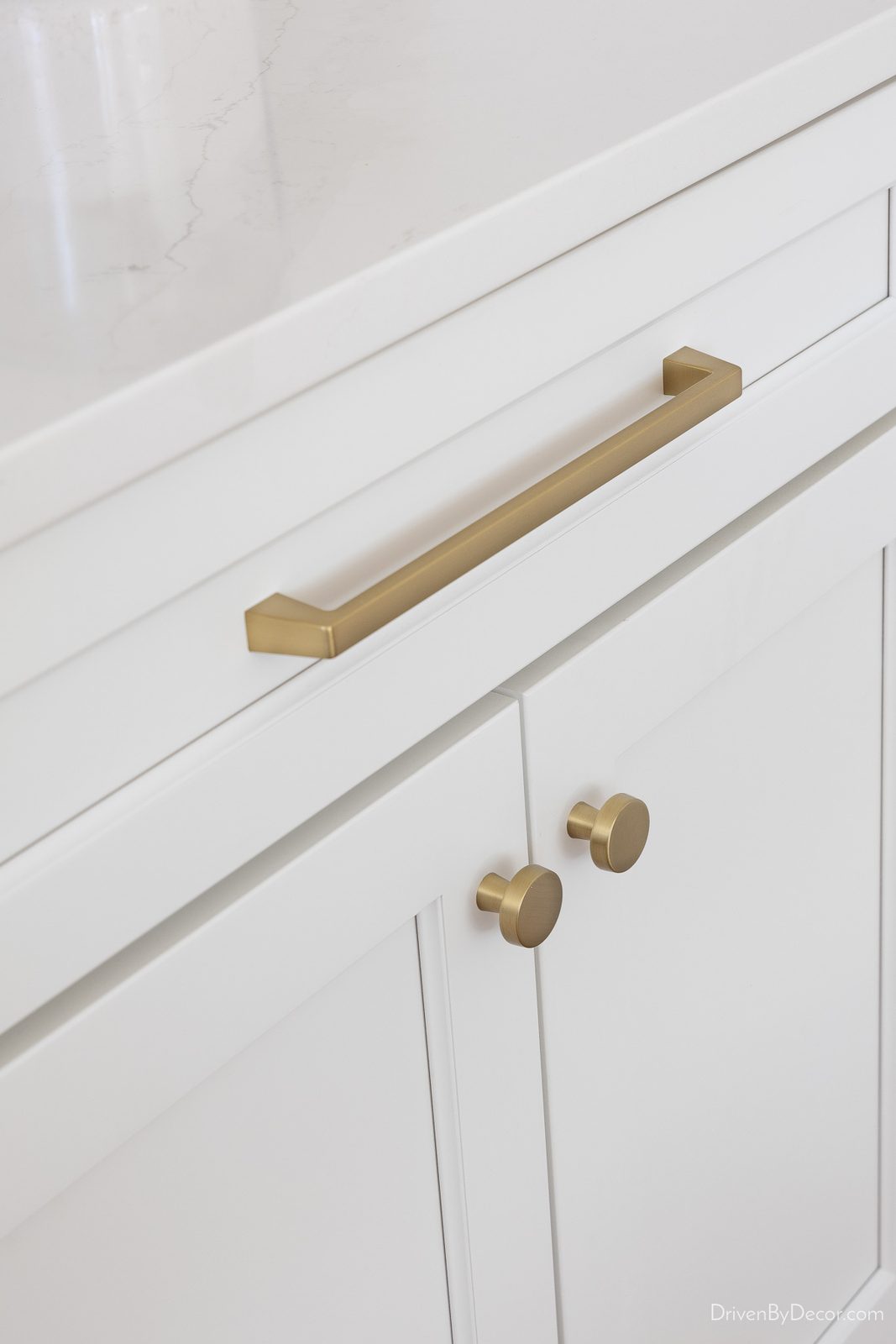 Gold pulls and knobs on white kitchen cabinets