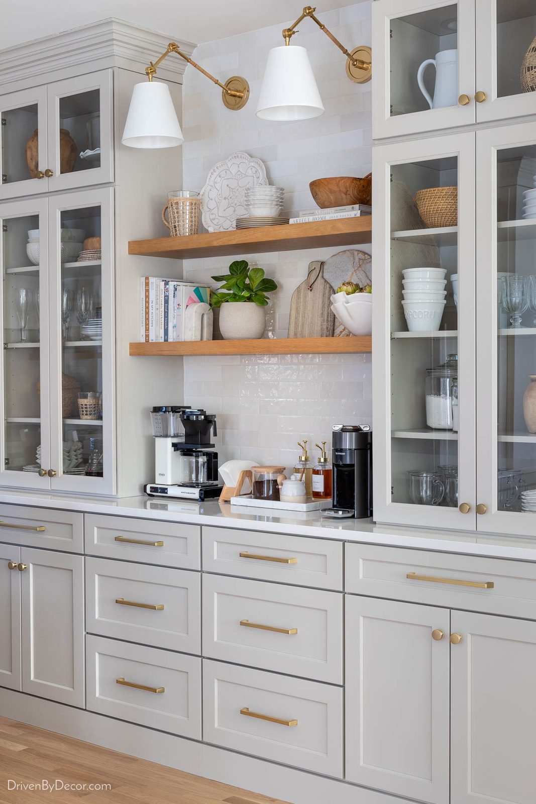 Kitchen coffee bar with glass door upper cabinets resting on quartz topped base cabinets