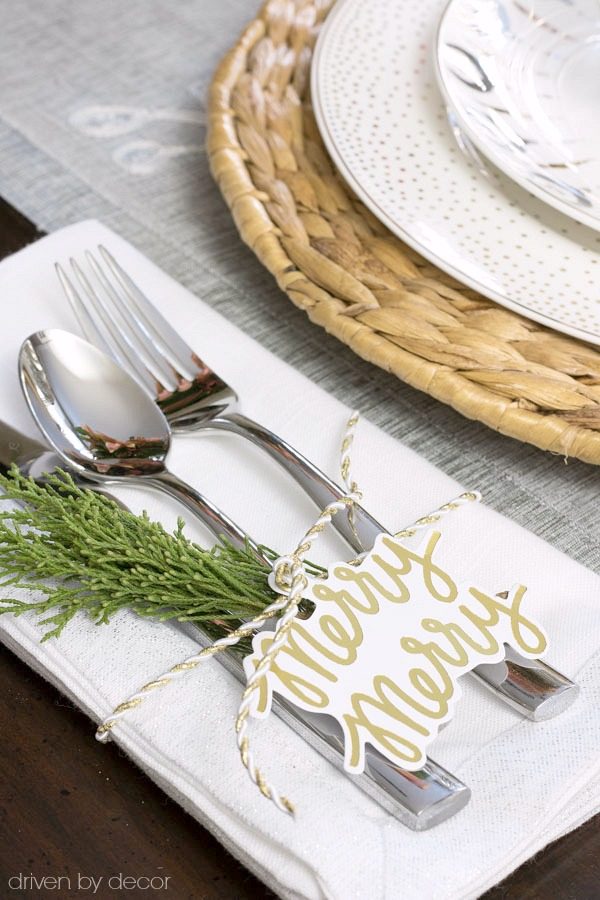 Holiday gift tags and a sprig of greenery adorn this simple Christmas placesetting