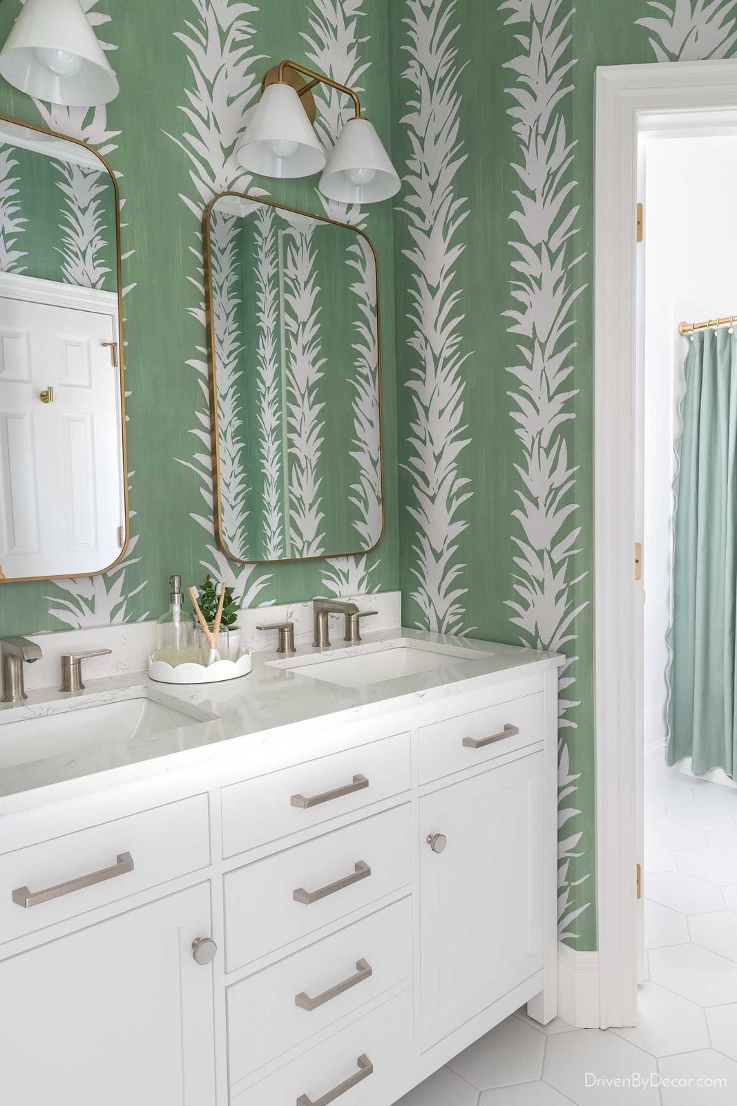 White bathroom vanity in bathroom with green wallpaper