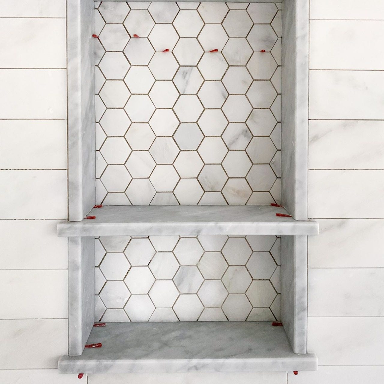 Gorgeous marble shower niche! Love the hexagon tile on the back of it!