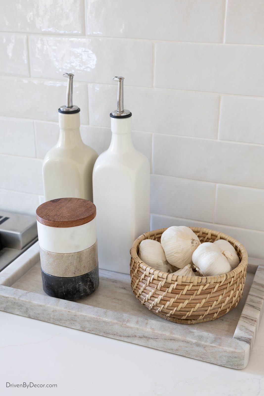 Marble tray next to range with oils, spices, and garlic basket