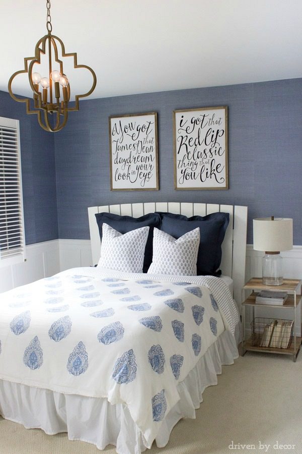 Modern coastal bedroom makeover with quatrefoil chandelier, grasscloth wallpaper, wood and chrome nightstand, and blue and white bedding - beautiful!