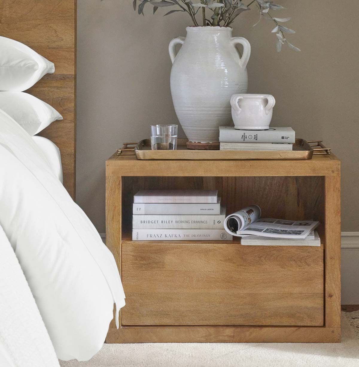 Tray on nightstand holding vase and other decor