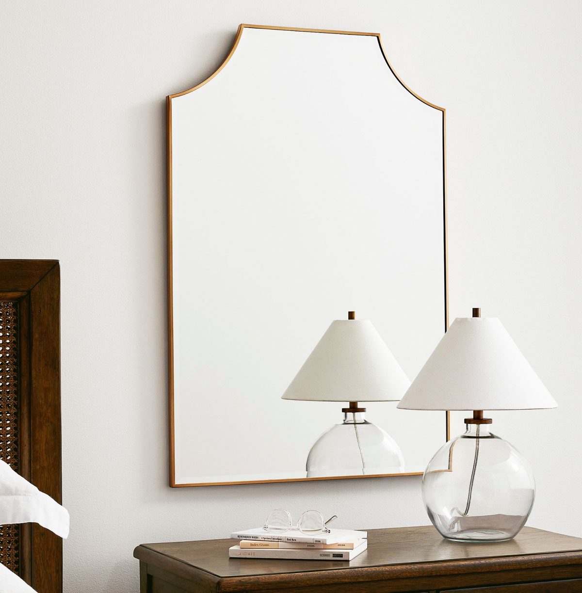 Mirror hung behind bedroom nightstand