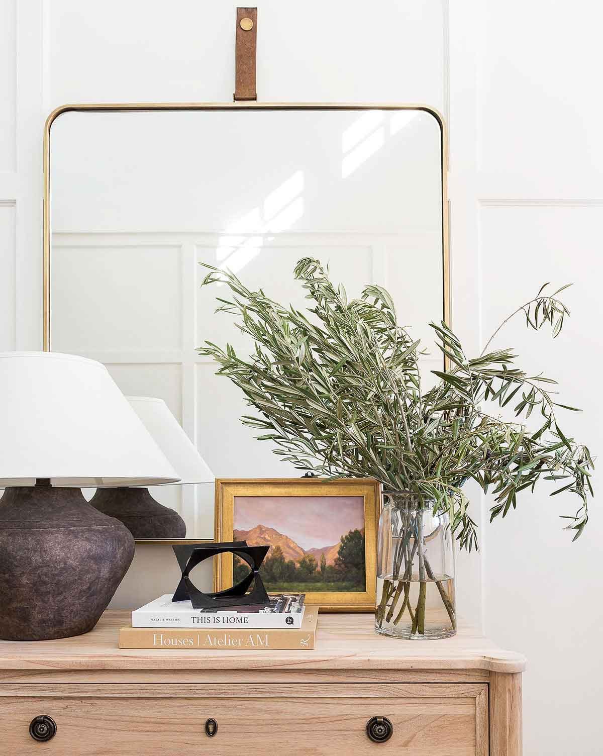 Mirror hung on wall behind nightstand as nightstand decor
