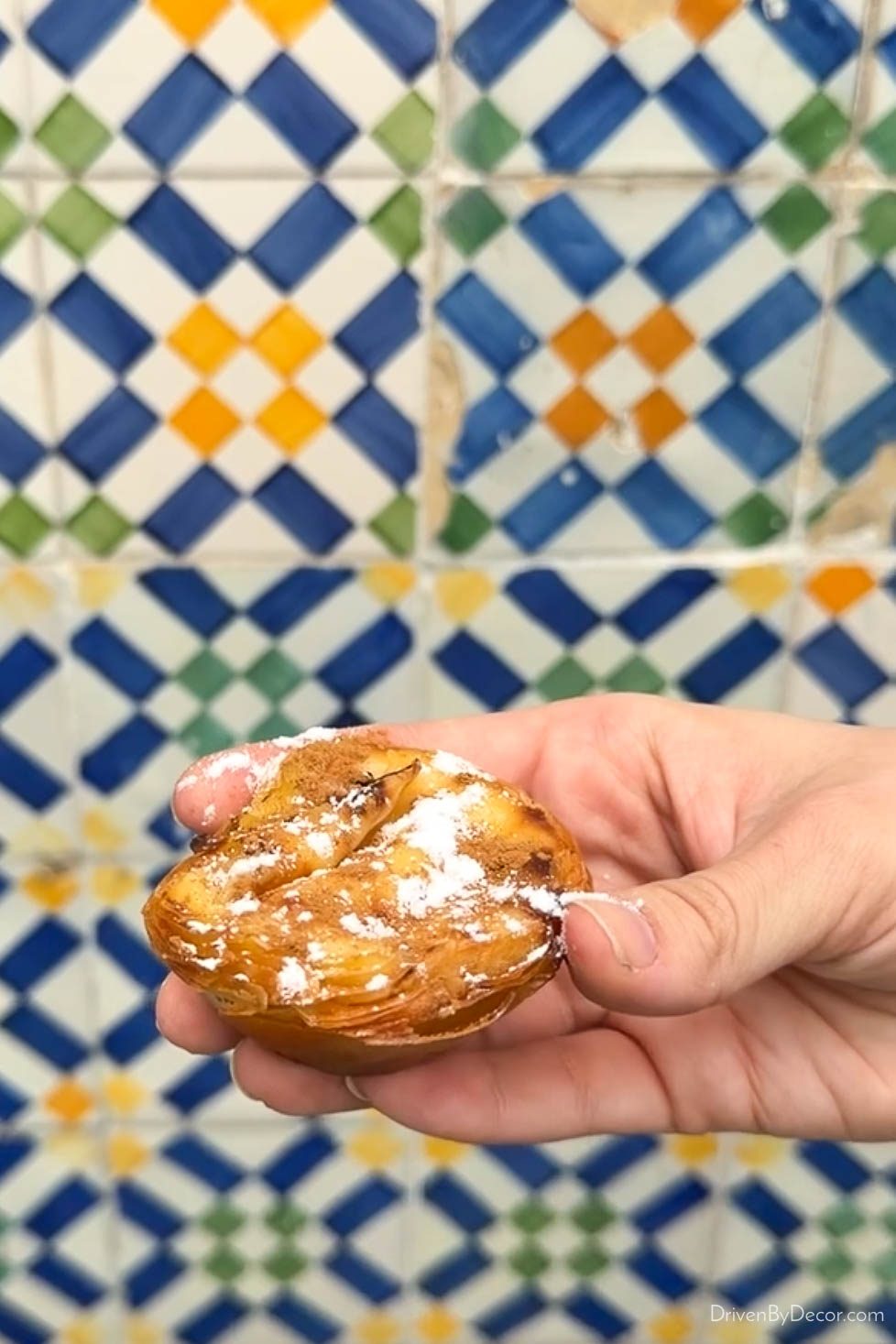 Pastel de nata pastry in front of tiled wall