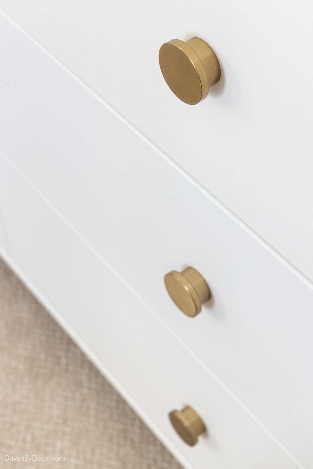 Modern brass knobs on a white dresser