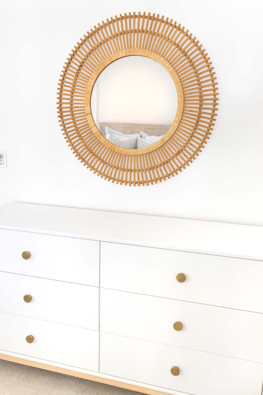 Large round rattan mirror above dresser