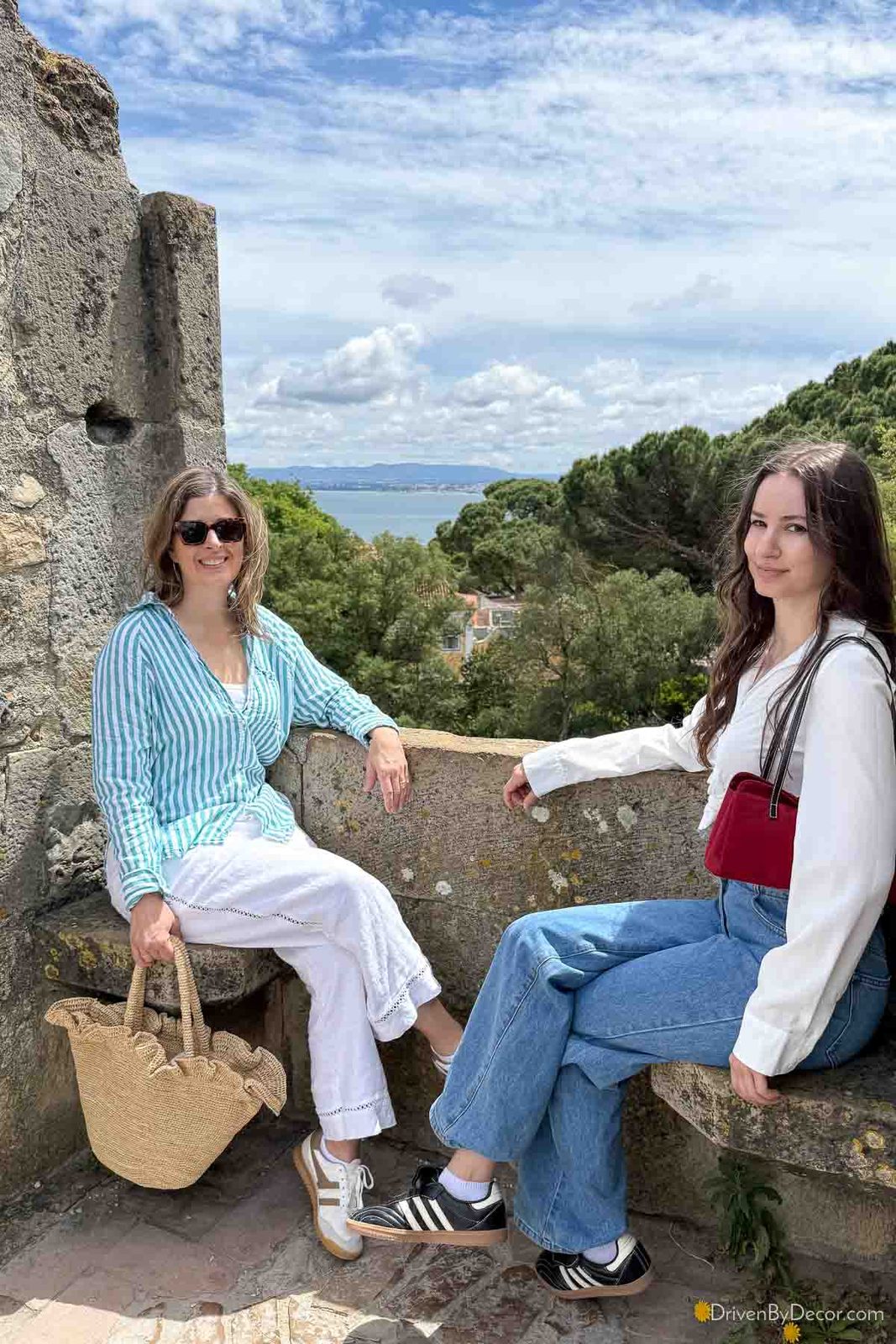 Two women sitting on benches at Sao Jorge Castle in Portugal