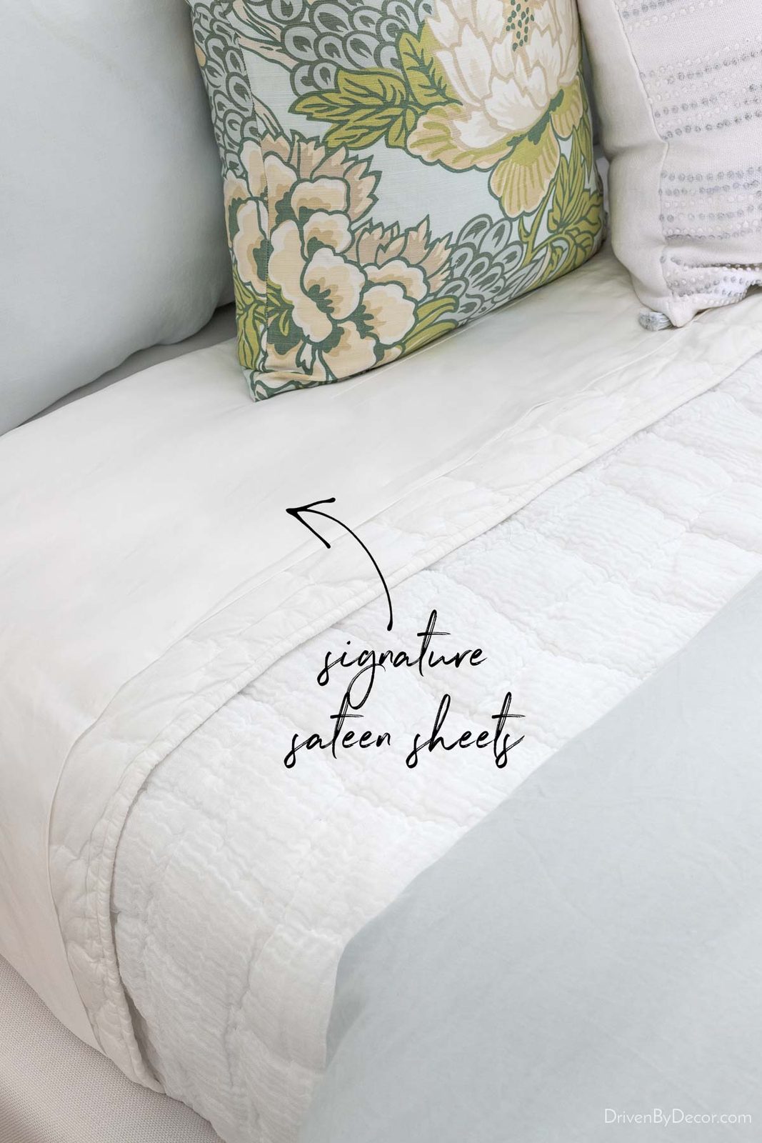 Multiple layers of bedding including Saatva's signature sateen sheets