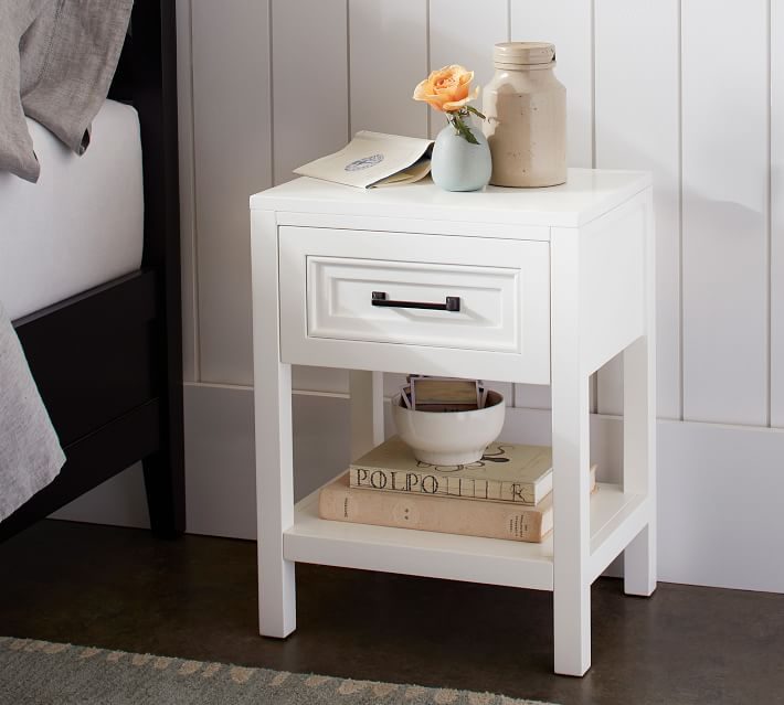 This small white nightstand is perfect for small spaces! Love the classic design with a drawer and shelf.