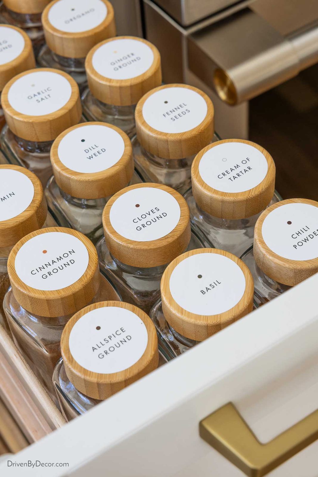 Spice pull-out in kitchen with labeled spice jars