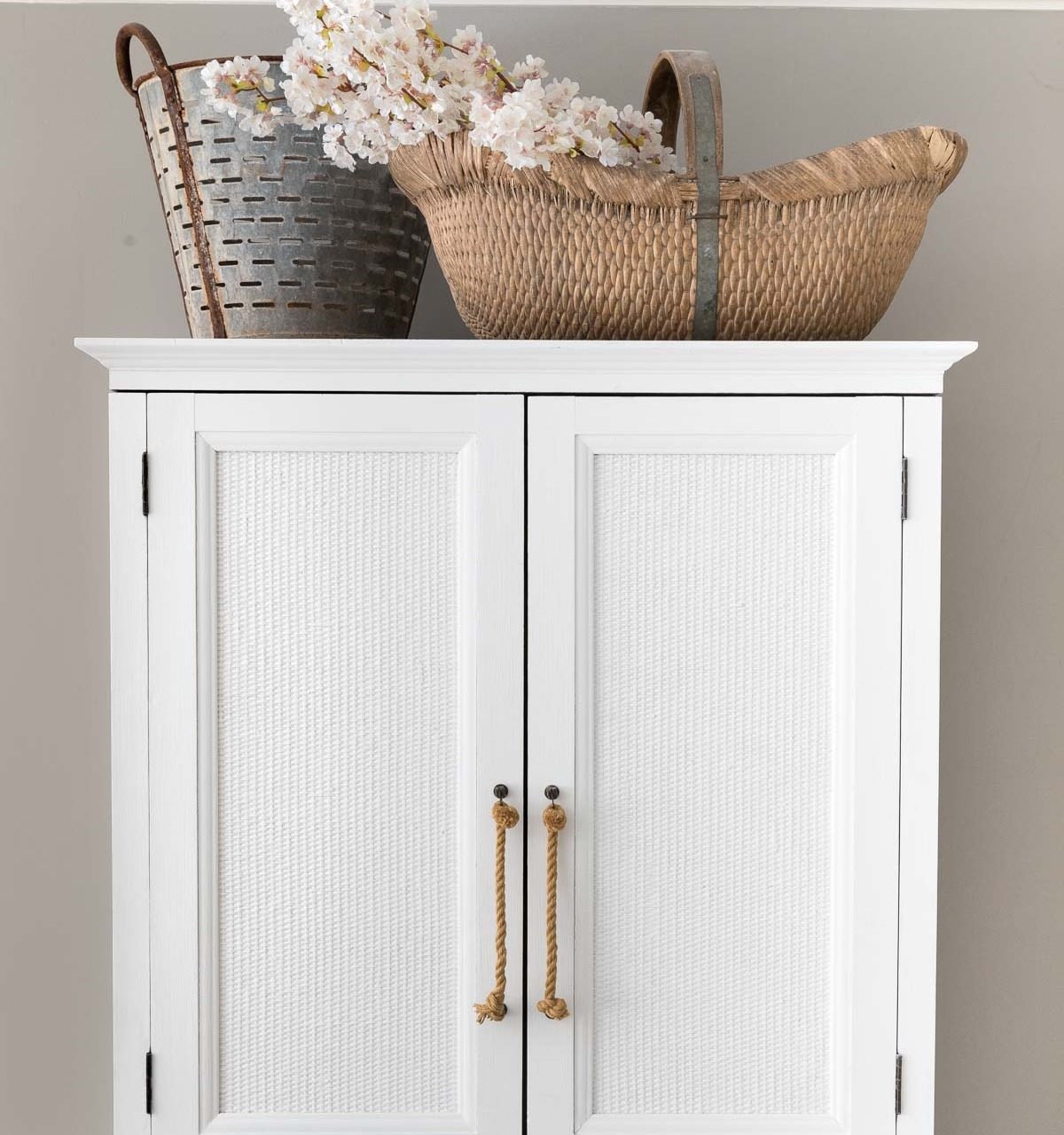 Gorgeous faux cherry blossom branches - the perfect spring decor for the basket on our armoire!