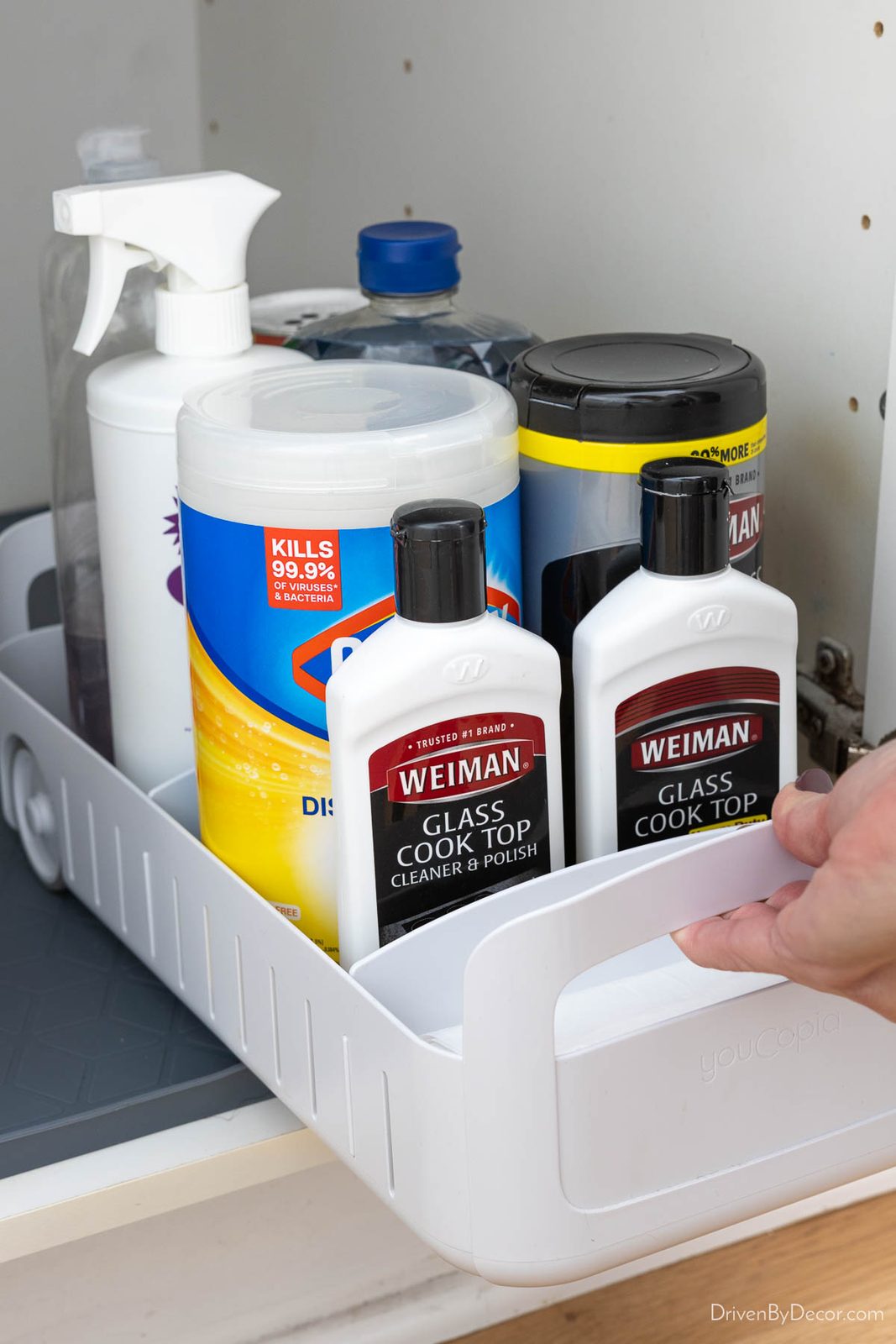 White rolling organizer filled with cleaning supplies
