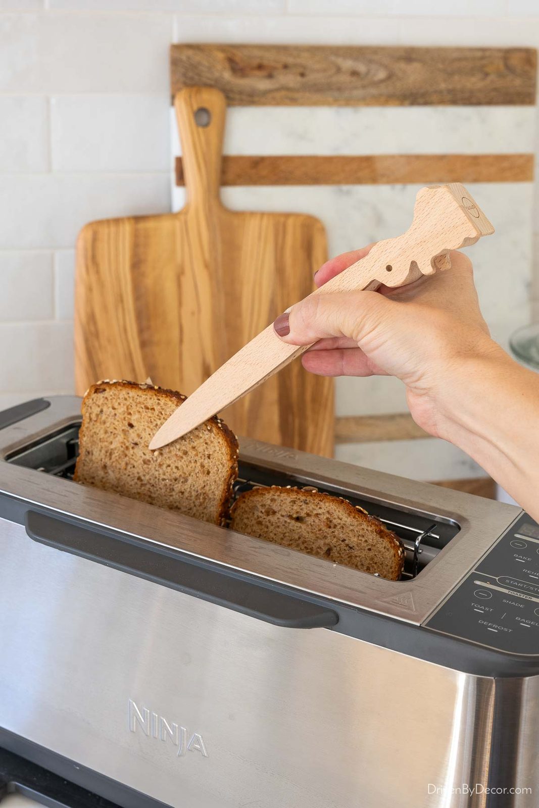 Wood tongs getting toast from toaster