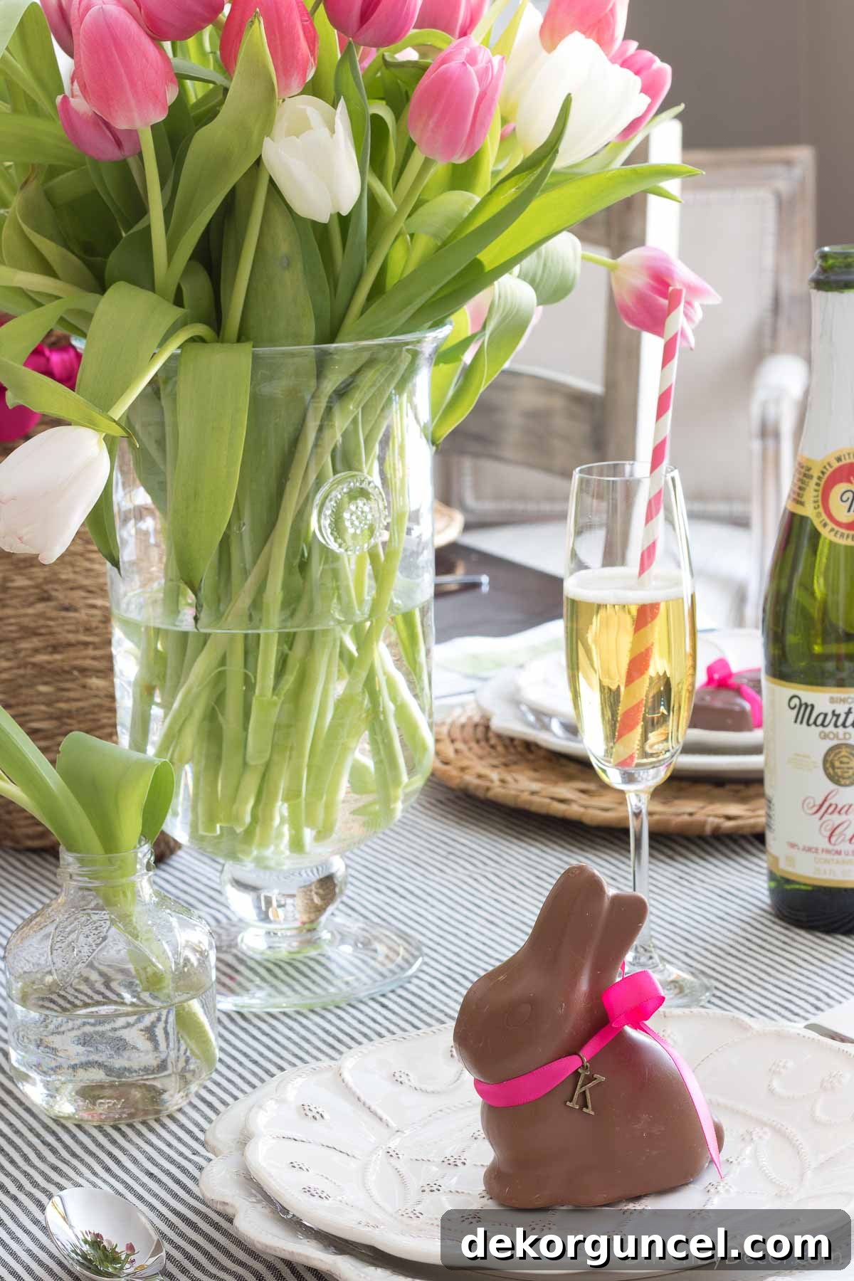 Close-up of a chocolate bunny place card on a plate, personalized with an initial charm tied around its neck with a delicate ribbon.