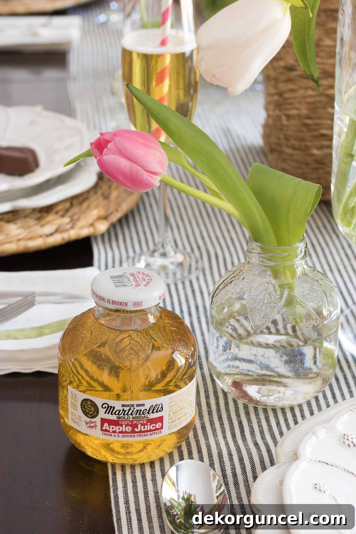 A collection of small apple juice bottles, cleverly repurposed into charming mini vases, ready for single-stem flowers.
