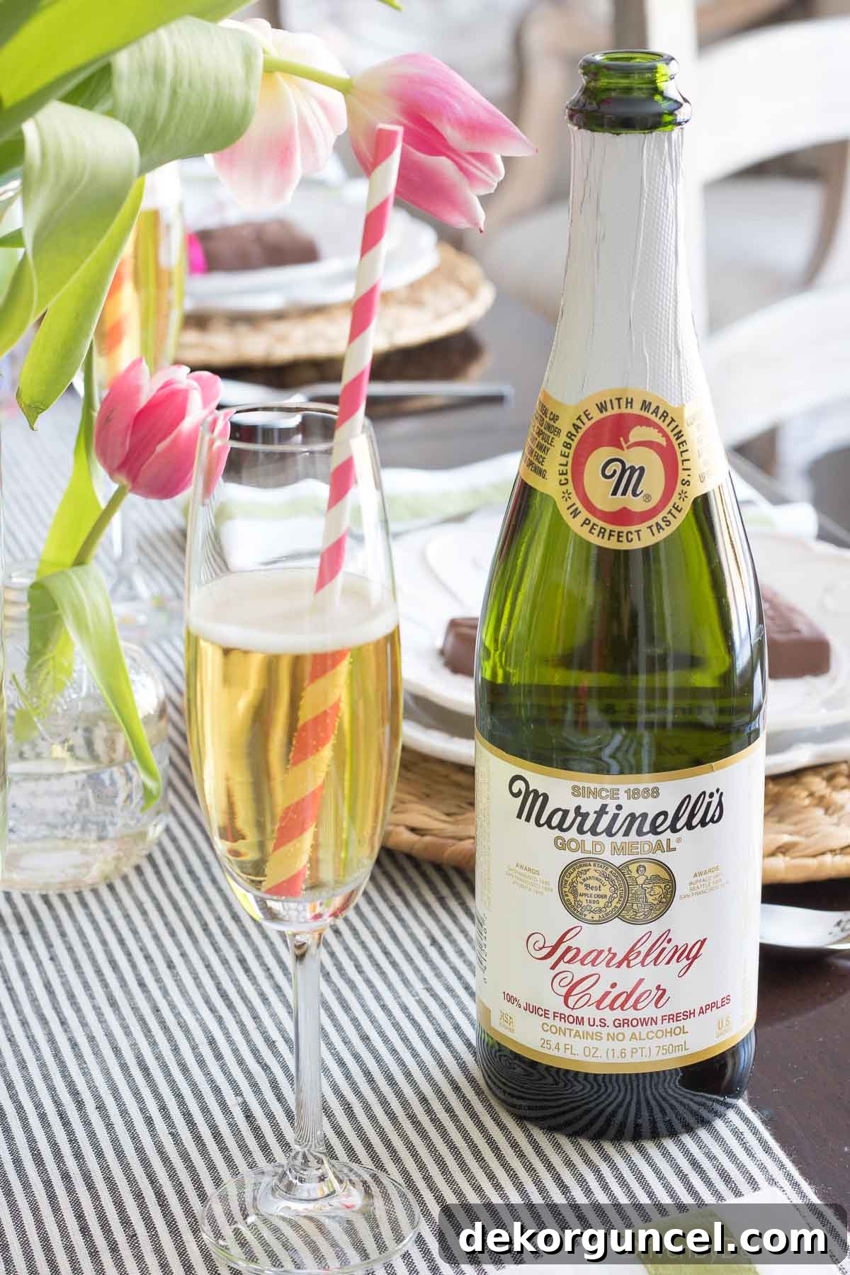 A glass containing a festive drink, adorned with a charming striped pink straw, adding a whimsical touch to the table setting.