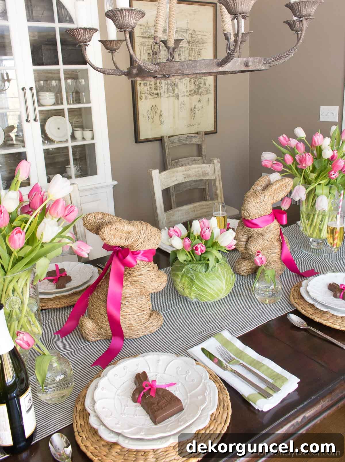 Elegant centerpiece featuring charming twine bunnies adorned with pink ribbons, surrounded by vibrant tulips, creating a festive Easter display.
