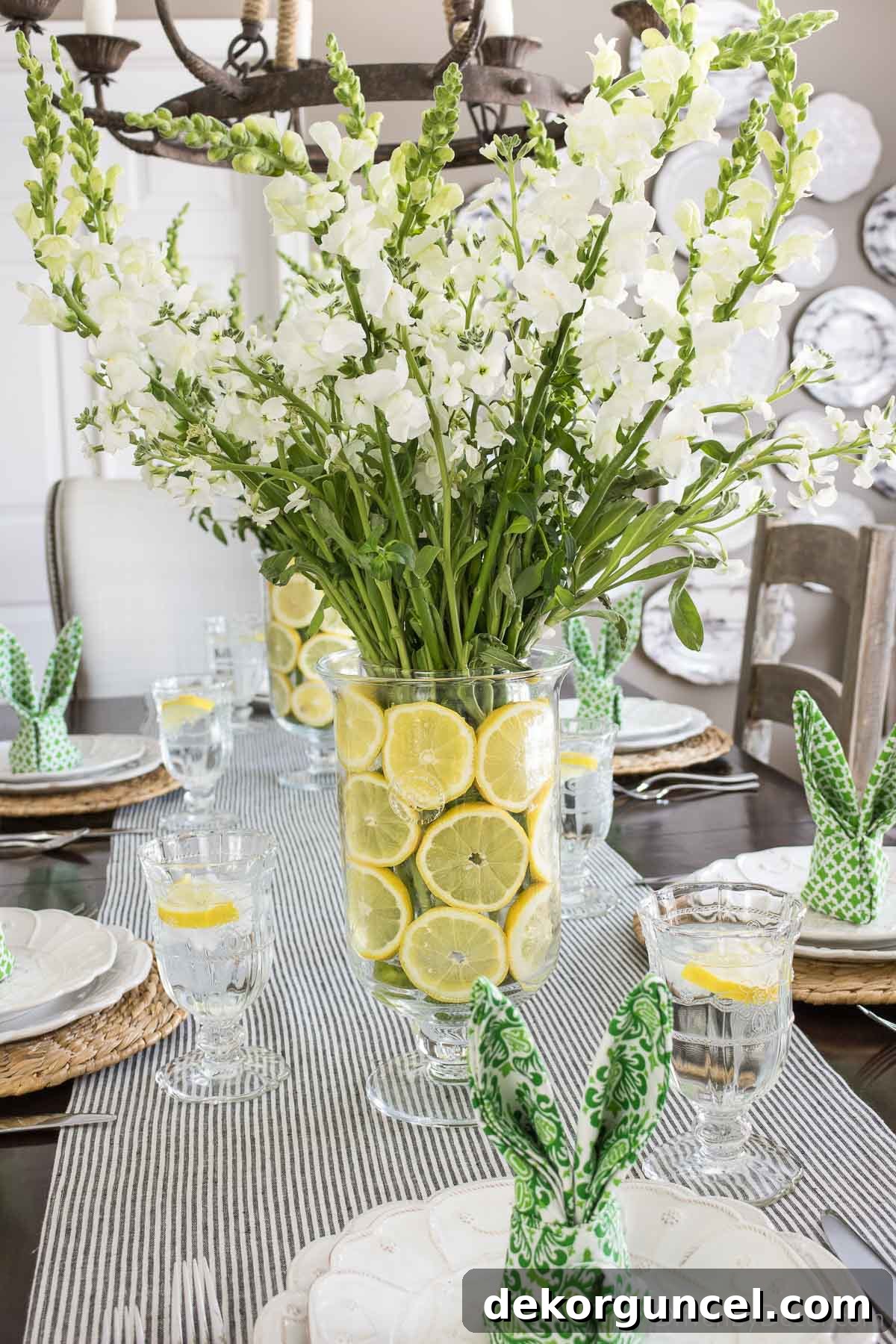 Beautiful Easter table centerpiece showcasing elegant glass vases artfully lined with fresh lemon slices, providing a vibrant and zesty visual appeal.