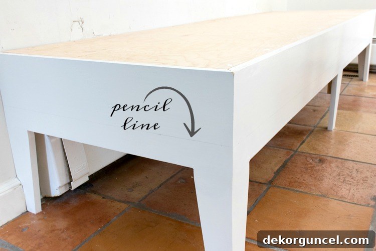 Build Your Own Banquette Seating 11 Adding fabric to the base of a kitchen banquette bench with a marked guideline.