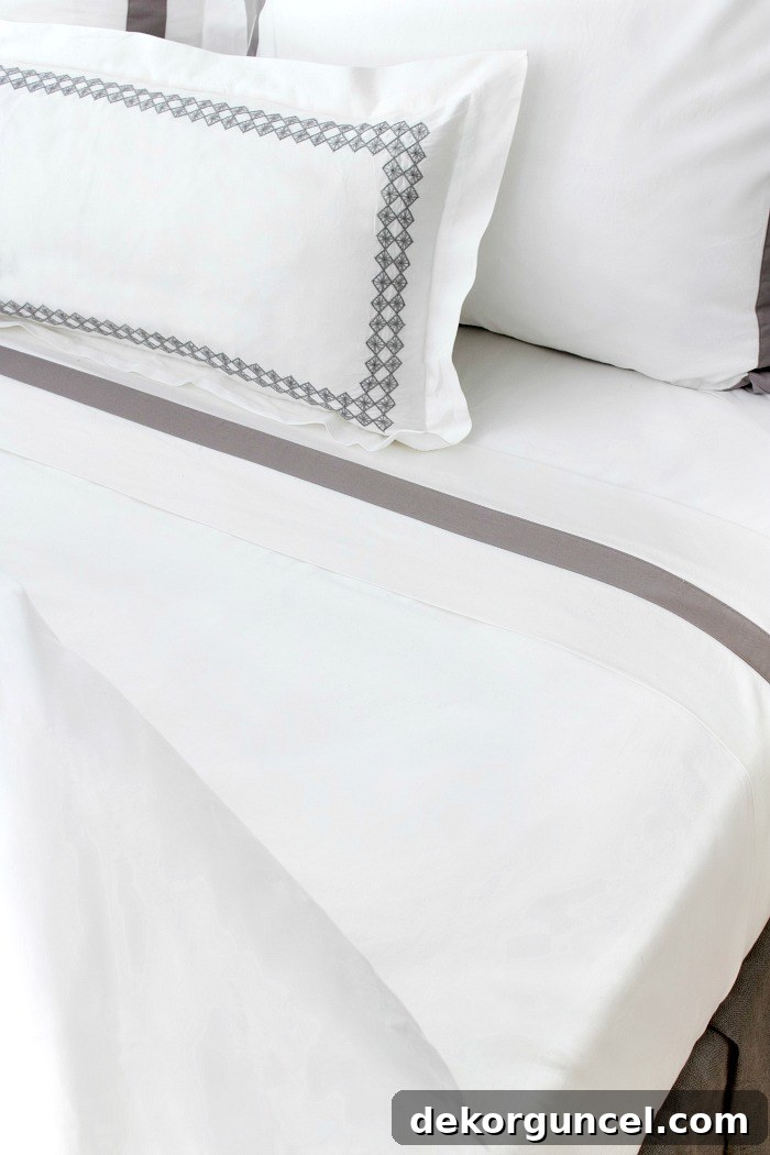 Close-up of soft, organic white Boll & Branch sheets on a bed, showcasing their luxurious texture.