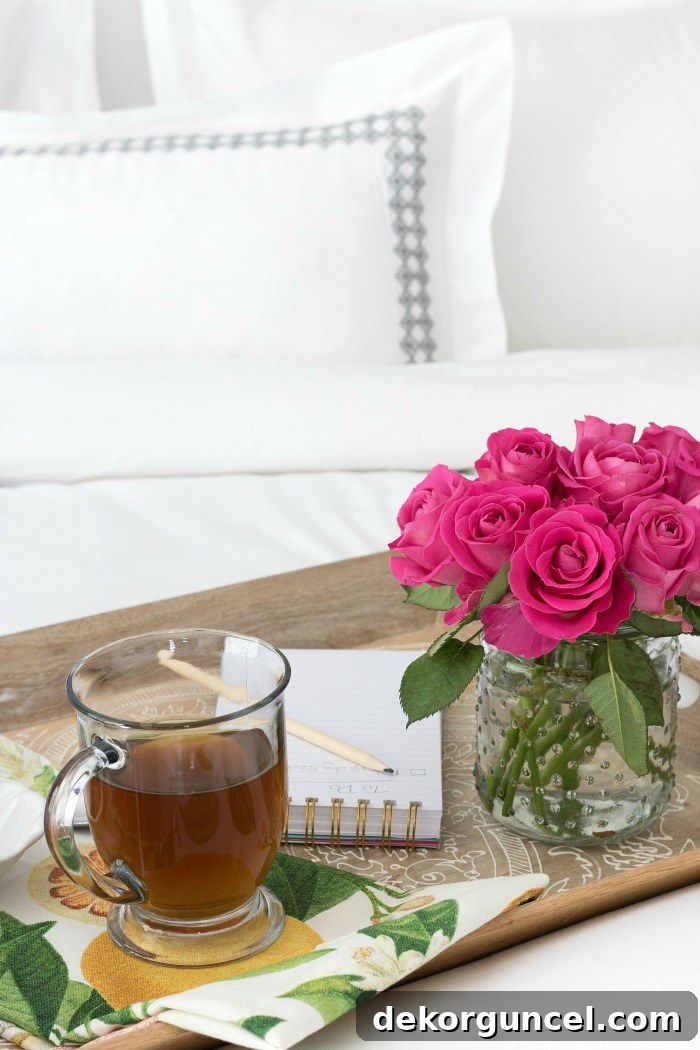 Breakfast in bed scene with a wooden tray, coffee in a glass mug, and elegant Boll & Branch bedding, illustrating a peaceful morning routine.