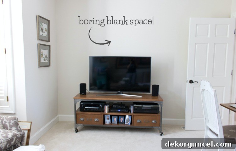Above TV Shelf: Smart Storage, Seamless Style 3 Image of a blank wall space above a TV before any decoration. The media console below the TV is also visible.