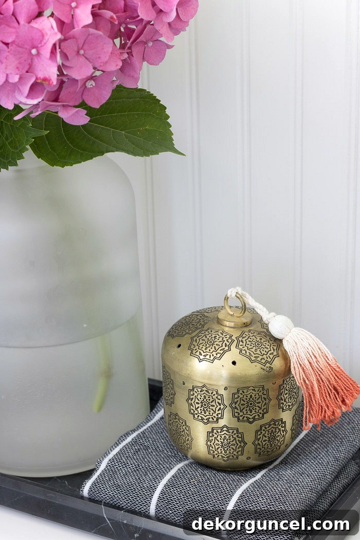 A tasseled brass vessel to hold Q-tips and cotton balls for guests - great toilet tank decor :)