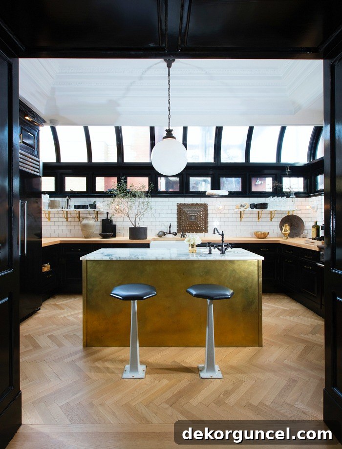 Gorgeous kitchen with herringbone wood floors, black cabinets, butcher block countertops, and gold island