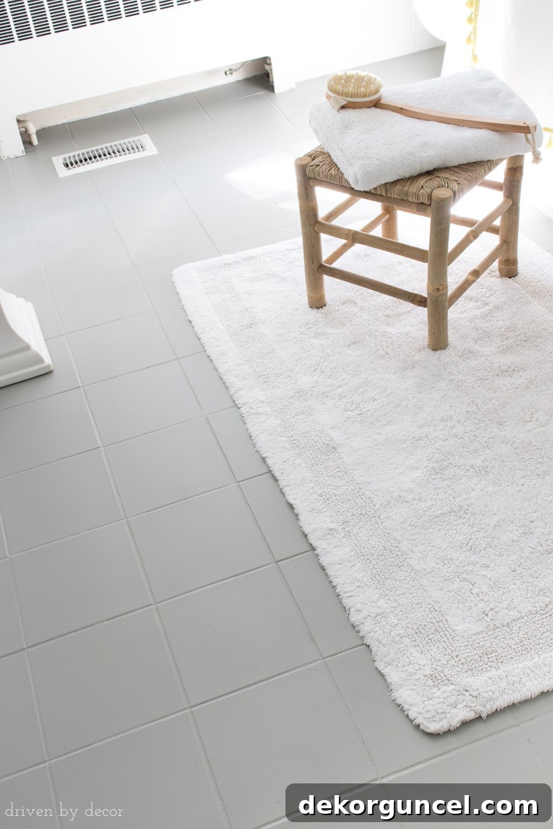 How to Paint a Tile Floor: Essential Tools and Proven Tips 11 Close-up of freshly painted gray ceramic tile bathroom floors, highlighting the smooth and even finish achieved through DIY painting.
