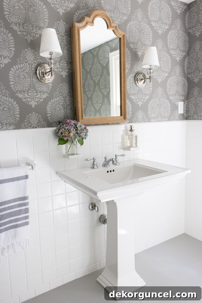 How to Paint a Tile Floor: Essential Tools and Proven Tips 13 Completely renovated bathroom featuring newly painted gray ceramic tile floors, elegant stenciled walls, an upgraded medicine cabinet mirror, and a modern pedestal sink.