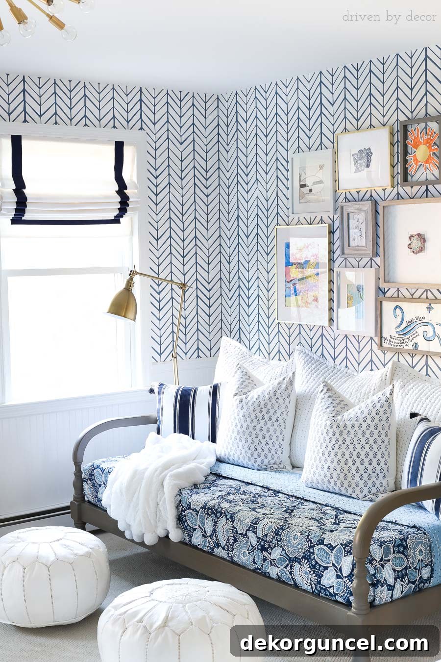 My Six Handpicked Kids Room Ideas 9 A charming blue and white bonus room area featuring a daybed, adorned with a blue floral quilt, blue and white pillows, white leather Moroccan poufs, Roman shades, and an inspiring art gallery wall.
