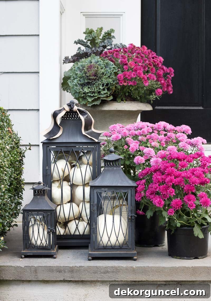Love this trio of black lanterns filled with pumpkins (and the mums too!) for a fall front porch