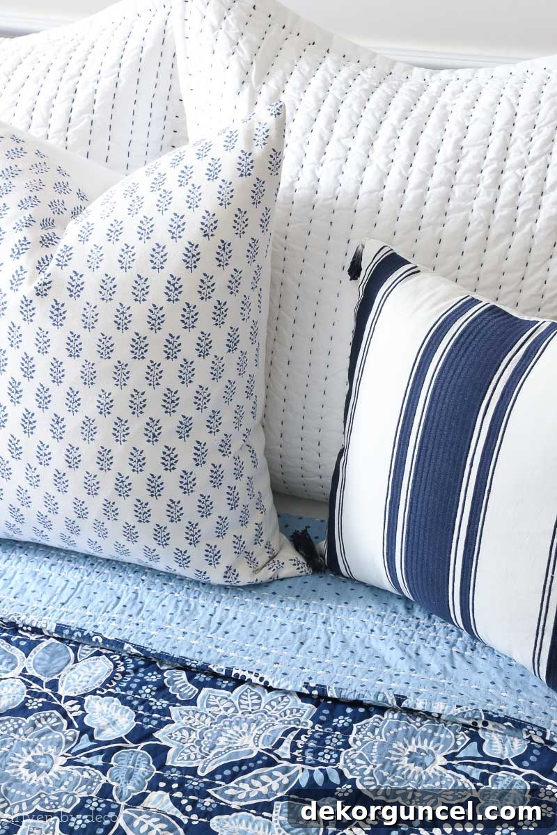 A stunning visual of blue and white pillows harmoniously combined with the floral Vera Bradley Traveler Floral bedding, creating a serene and inviting bedroom aesthetic.