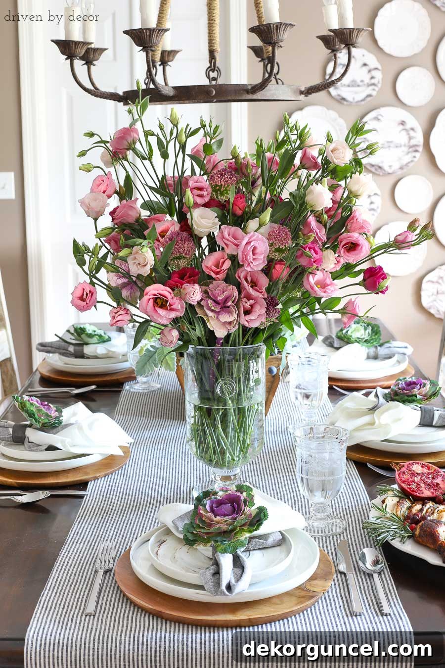 Simple dining room table setting for Thanksgiving with fresh flowers for a centerpiece and faux kale tucked into napkins