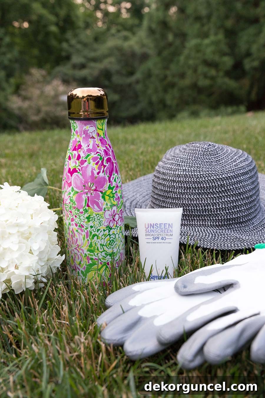 Essential gardening items: wide-brimmed hat, invisible sunscreen, protective gloves, and a water bottle.