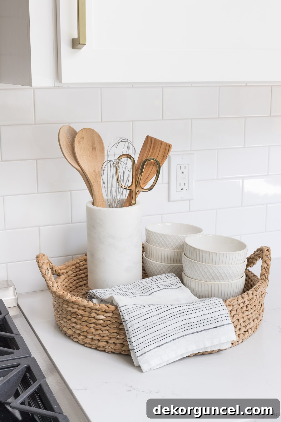 Our Kitchen Remodel: From Drab to Dreamy 18 Crafting the ideal kitchen setup next to your range: a round woven tray neatly organizes essential utensils in a chic marble holder, complemented by a convenient hand towel and stylish white patterned bowls. Perfect kitchen accessories.