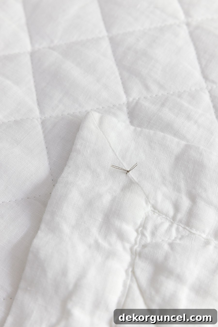 A genius bed-making tip: a small, discreet knot on the underside of a sheet's bottom corner simplifies bed setup and saves time.